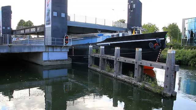 Schip ligt klemvast onder brug na botsing in Weert